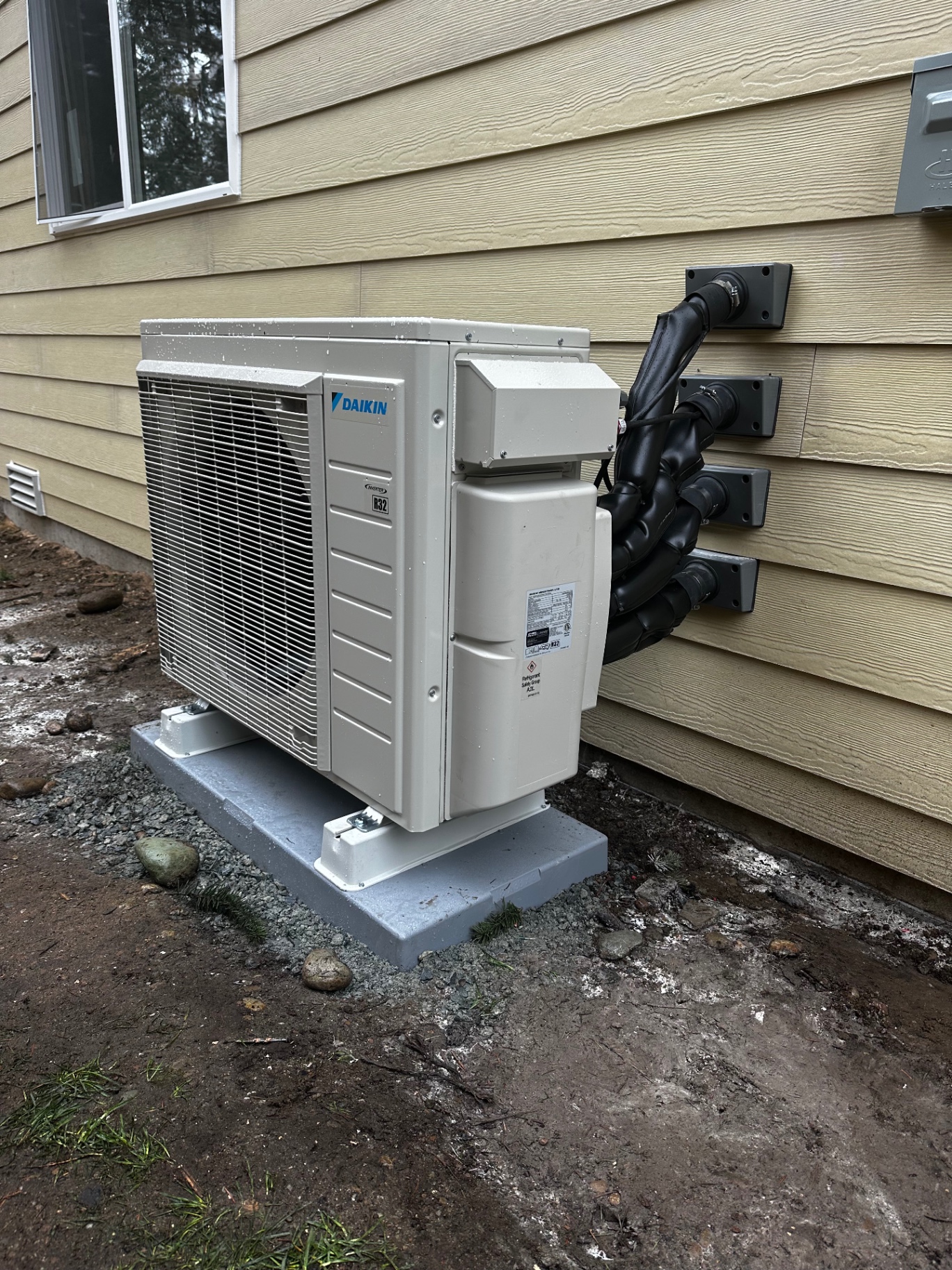 Daikin heat pump outdoor unit on a raised stand